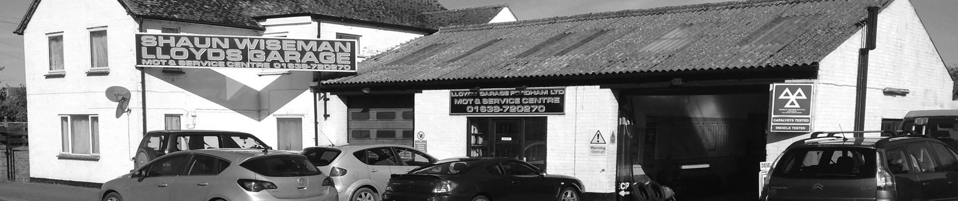 The open MOT bay and vehicle testing station sign at Lloyds Garage, Fordham